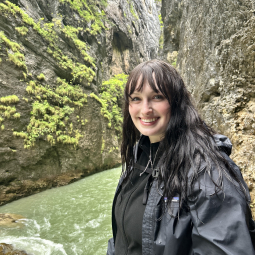Taylor Mugford stands in a gorge at the top of a waterfall